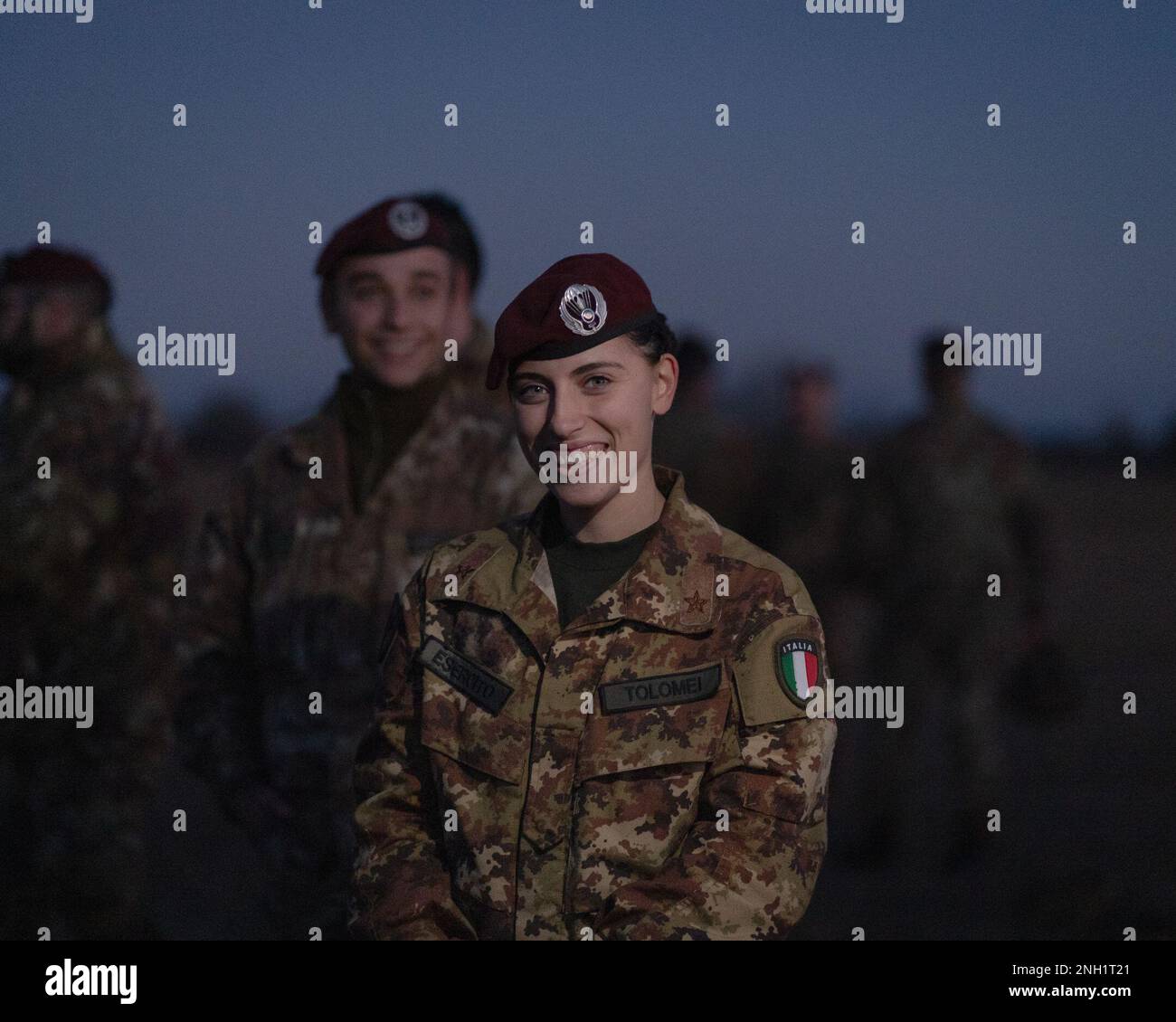 An Italian Army paratrooper with the Brigata Paracadutisti 'Folgore' shows excitement upon receiving her American Parachutist Badge after conducting an airborne operation alongside U.S. Army paratroopers assigned to the 173rd Airborne Brigade at Frida Drop Zone in Pordenone, Italy, Dec. 7, 2022.     The 173rd Airborne Brigade is the U.S. Army's Contingency Response Force in Europe, providing rapidly deployable forces to the United States European, African, and Central Command areas of responsibility. Forward deployed across Italy and Germany, the brigade routinely trains alongside NATO allies Stock Photo