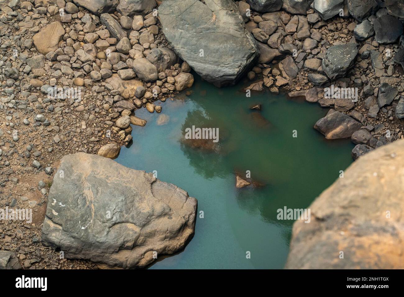 turquoise color water body and big rocks and small different shape ...