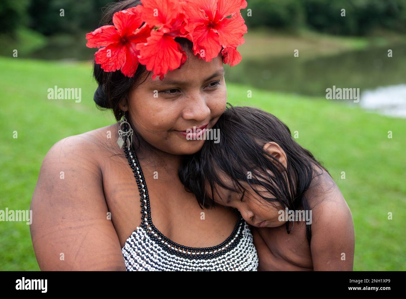 An indigenous Embera woman with her toddler asleep on her shoulder in an Embera village in Panama. Stock Photo