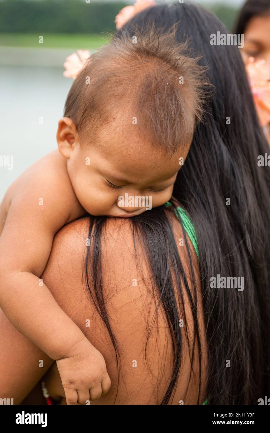 An indigenous Embera woman with her baby asleep on her shoulder in an Embera village in Panama. Stock Photo