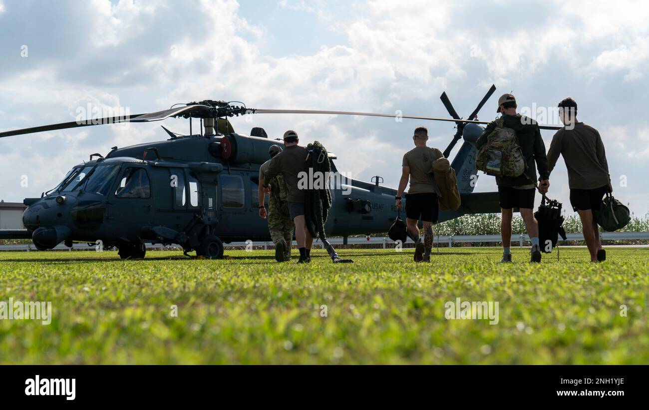Airmen assigned to the 33rd Rescue Squadron move cargo to an HH-60 Pave ...