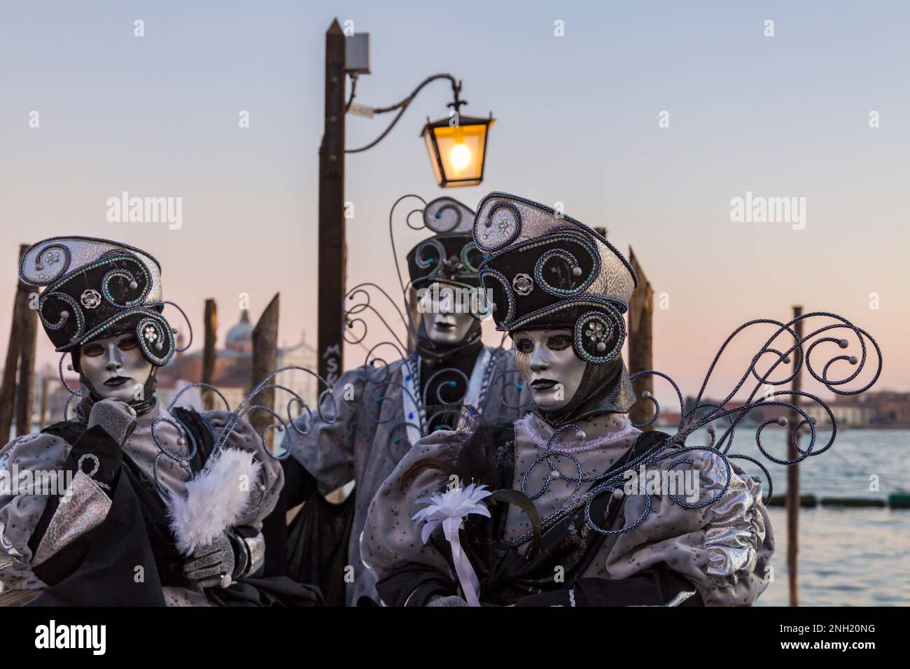 Carnival goers dressed in splendid costumes and masks during Venice