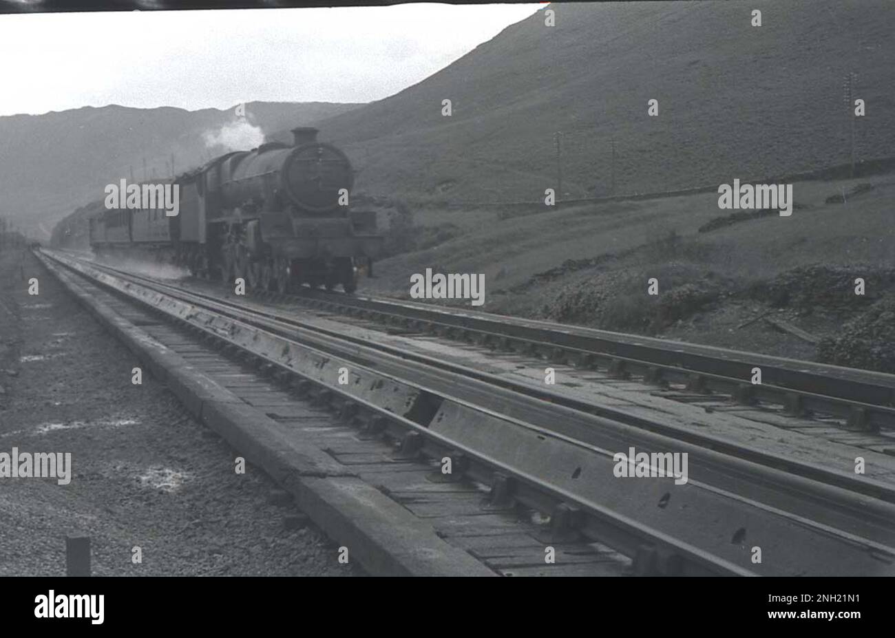 A named LMS Jubilee Class 4-6-0 steam locomotive hauls an express at Dillicar water troughs south of Tebay in Cumbria Stock Photo