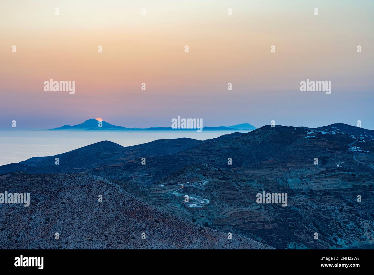 Sun setting behind Milos island seen from Folegandros Stock Photo