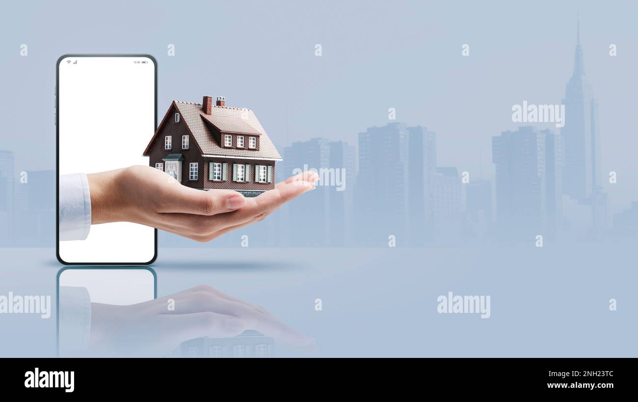Real estate agent hand showing a model house in a smartphone screen, real estate app concept