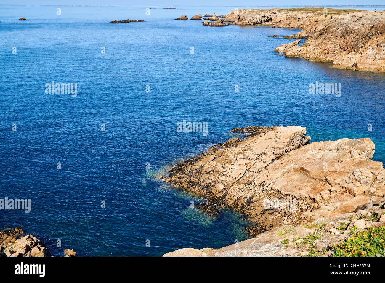 Sun-drenched cliffs with clear sea water Stock Photo