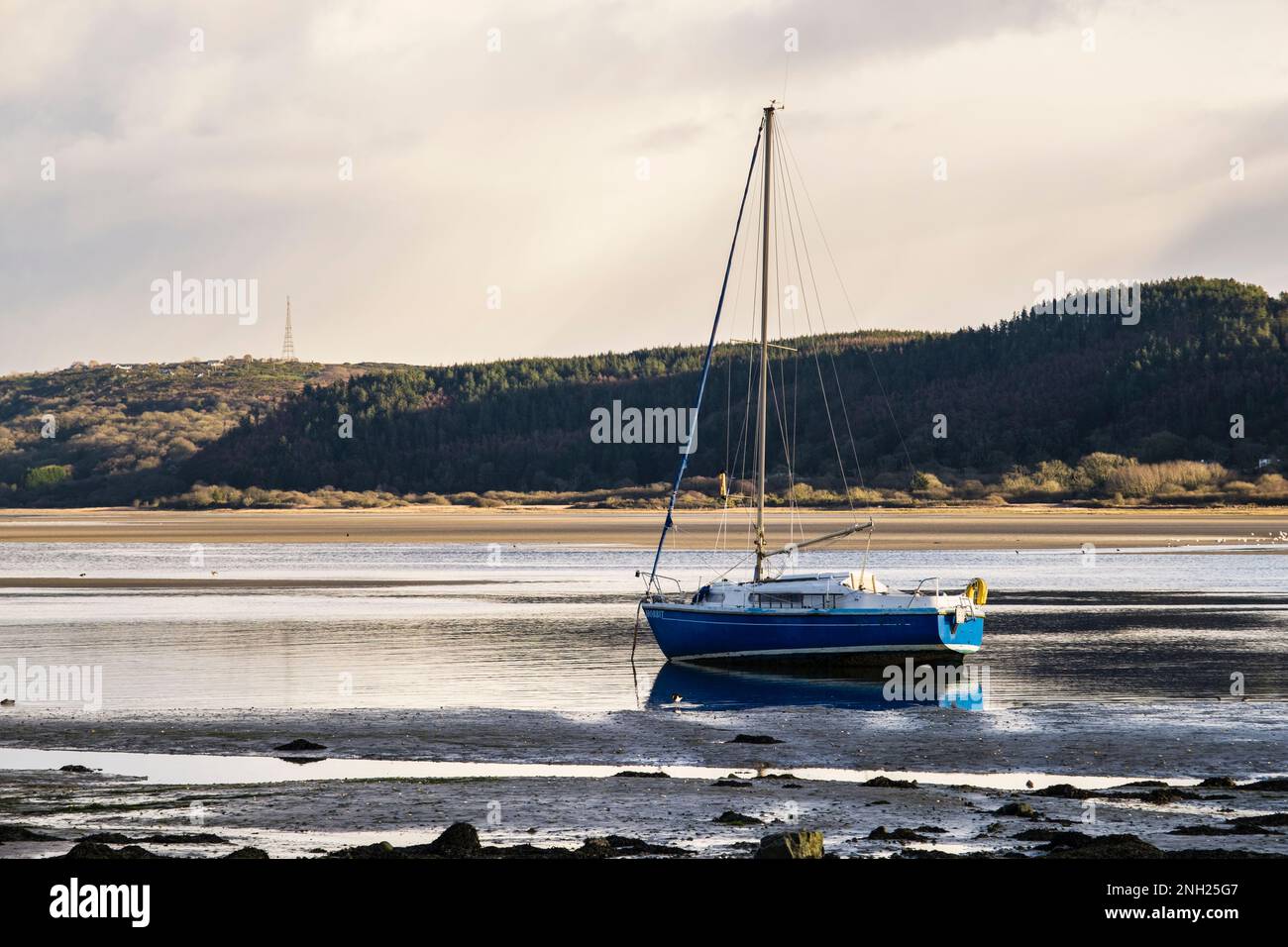 Grounded boat waits for the tide to come in. Red Wharf Bay (Traeth Coch), Benllech, Isle of Anglesey (Ynys Mon), Wales, UK, Britain Stock Photo