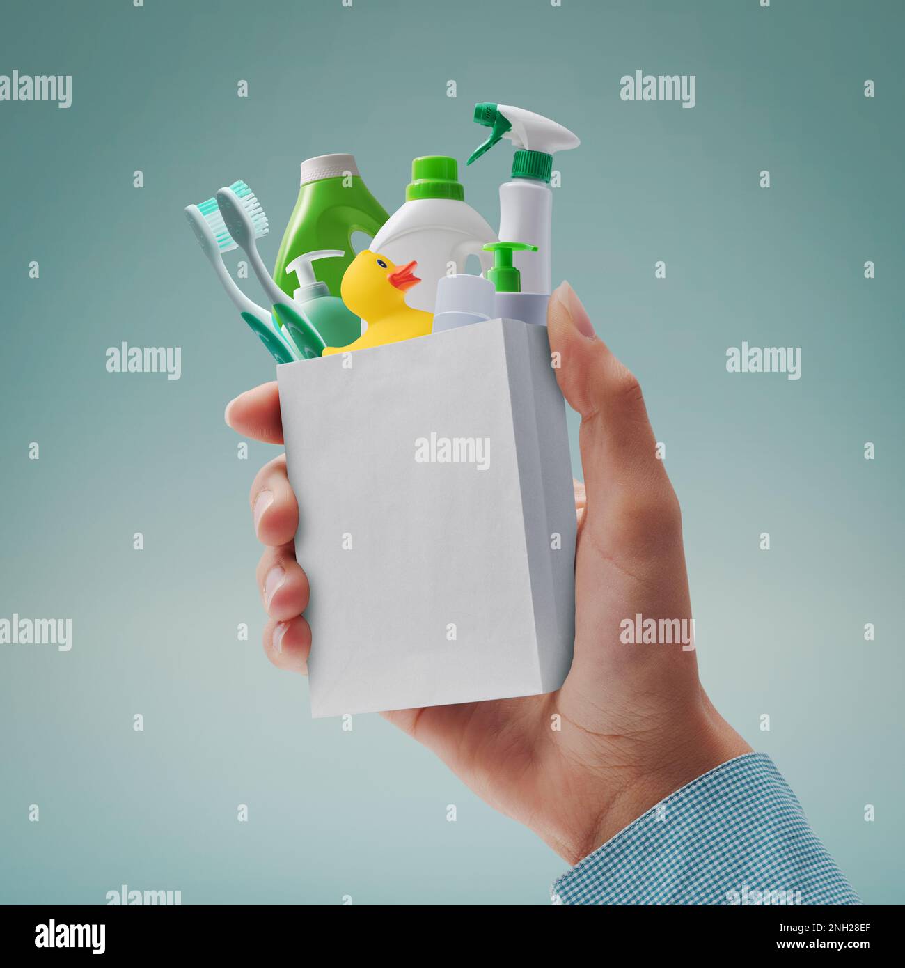 Customer holding a tiny shopping bag with assorted household items Stock Photo