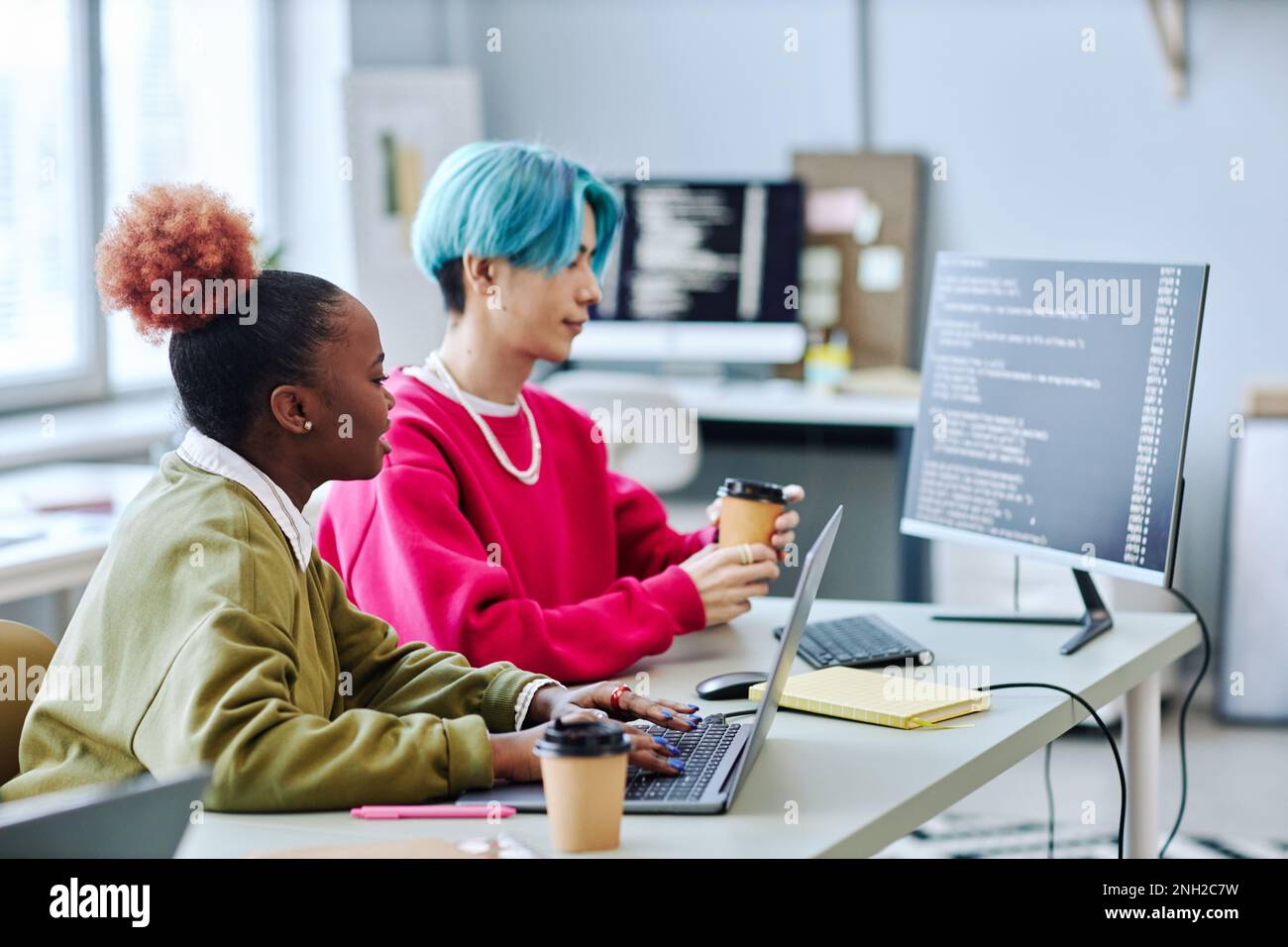 Gen Z creative team working on software programming in office, side view Stock Photo