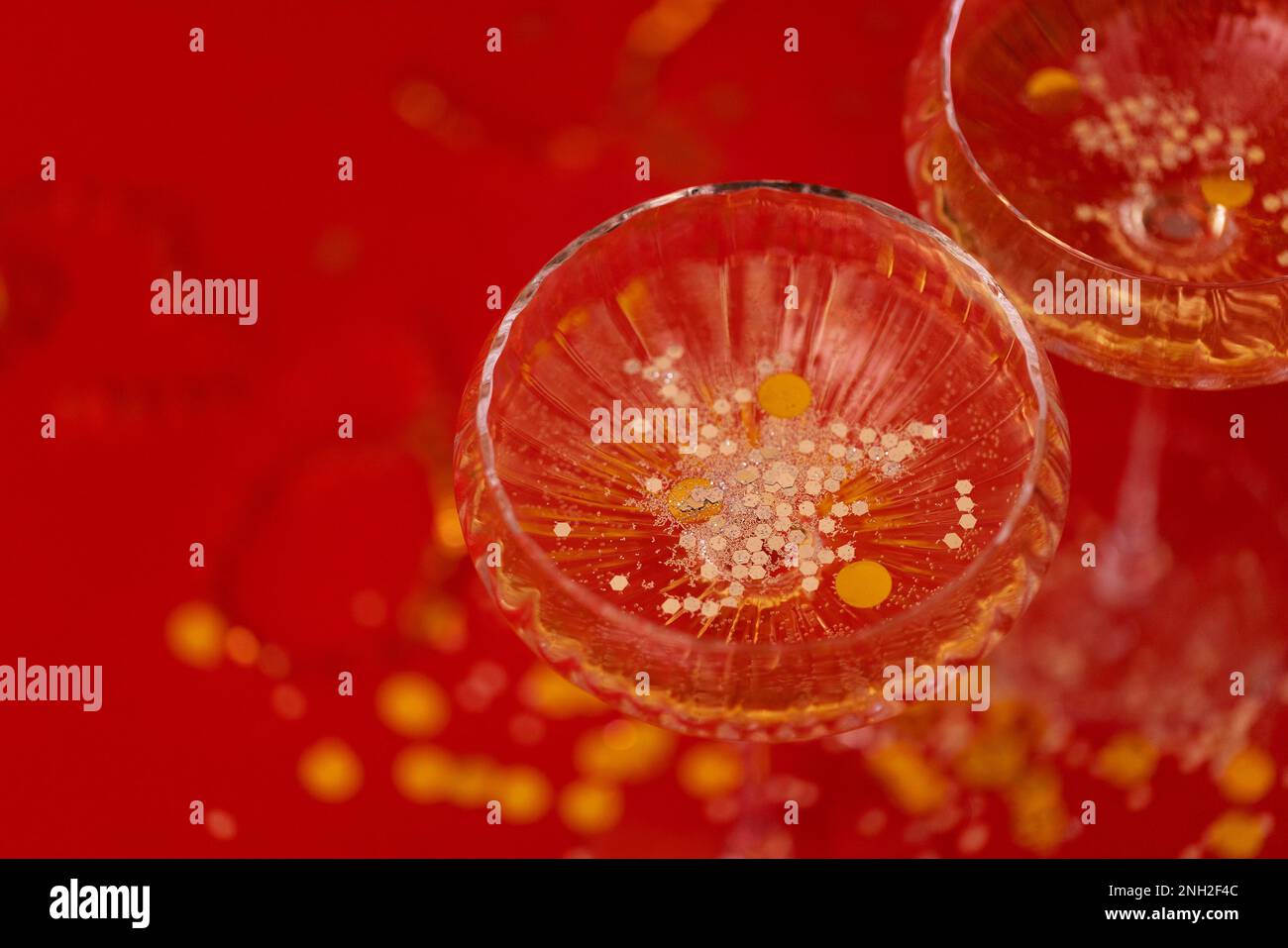 Two exquisite glasses of champagne with silver glitters and confetti