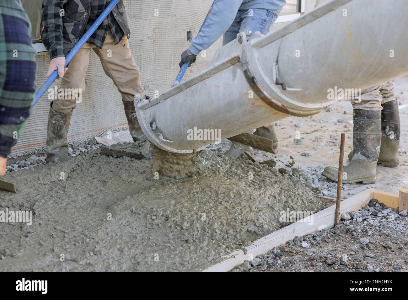 It is concrete mixing truck pouring concrete around new house that will