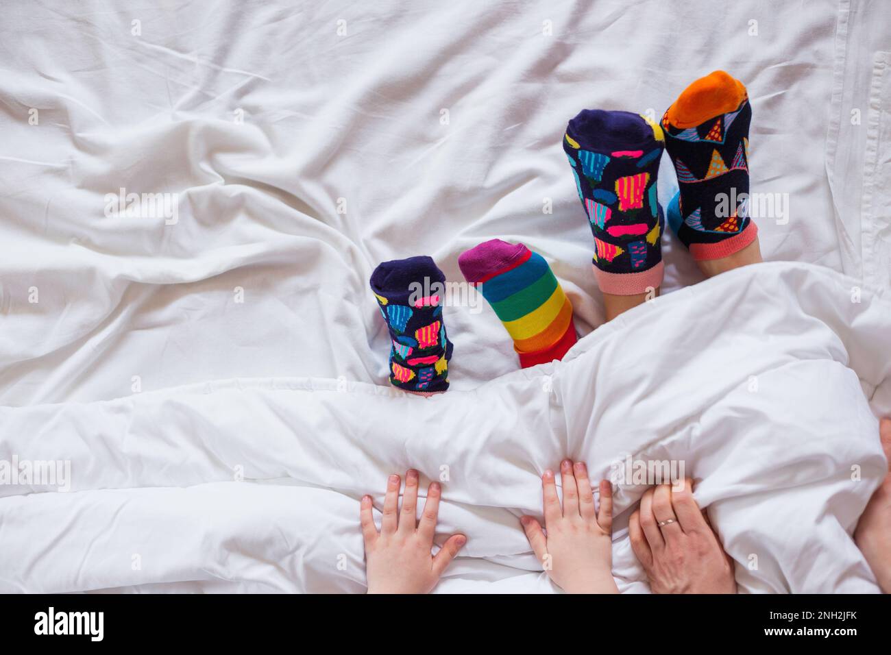 Colorful socks on feet as a symbol of World Down Syndrome Day. Stock Photo