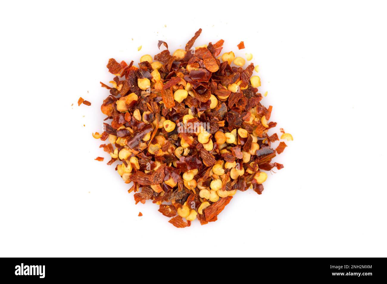 The pile of a crushed red pepper, dried chili flakes and seeds isolated on white background
