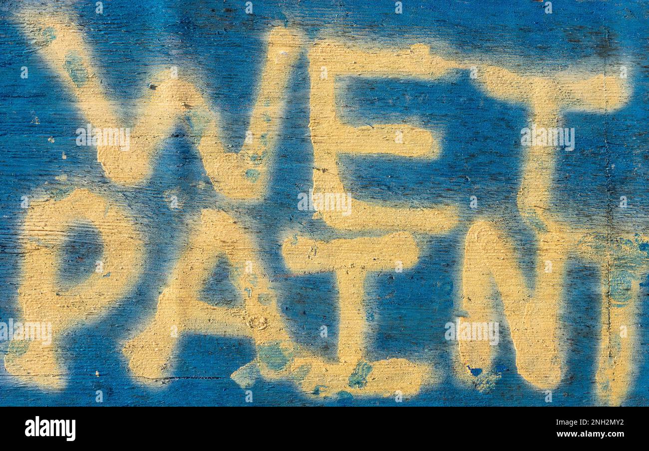 Paintedn 'wet paint' sign on an old brick wall Stock Photo Alamy
