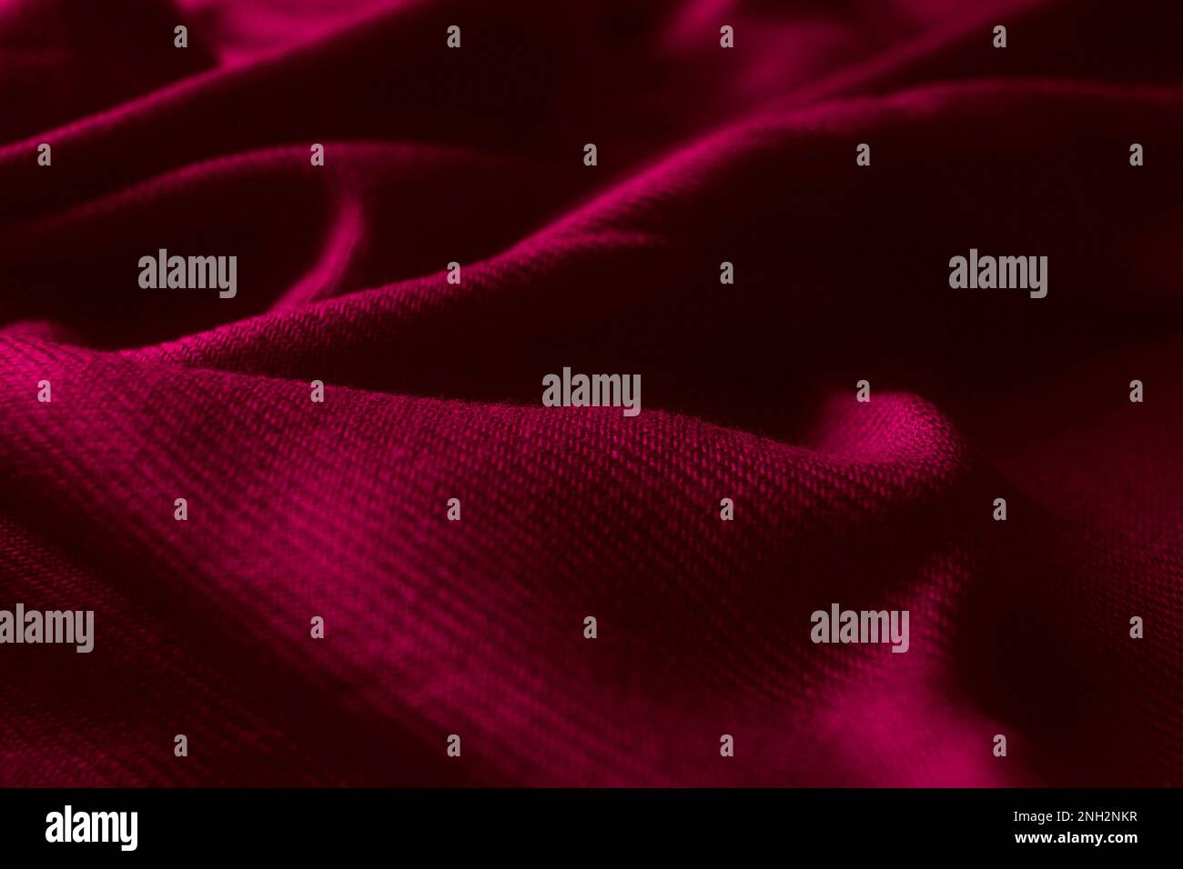 Fabric texture background of magenta color (Viva Magenta). Close up of