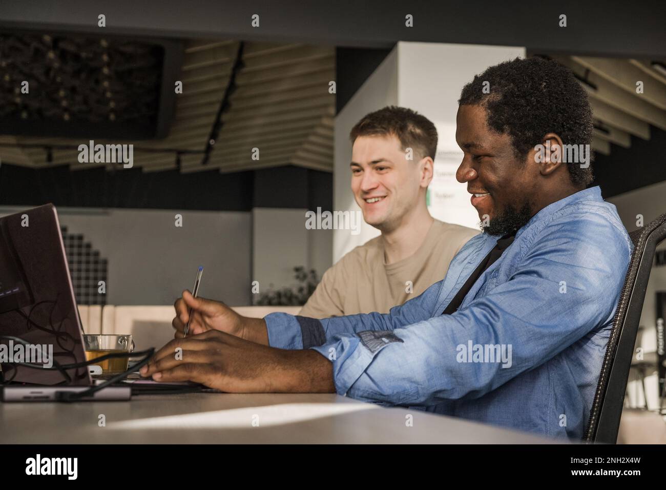 Two programmers working in the office of a software development company. Coding technologies, site design. Successful diverse Teamwork. Cyberspace Stock Photo