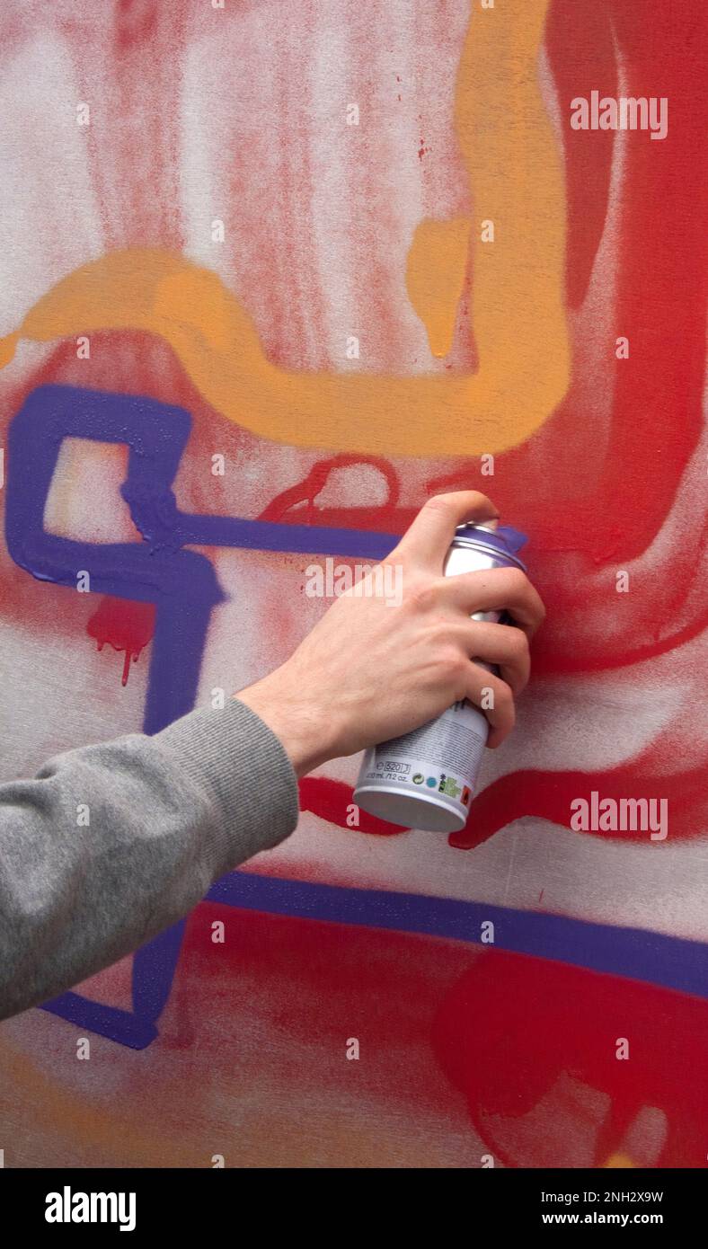 Graffiti show in Bacon St London E2. Artist working on building site hording part of weekend long project. Stock Photo