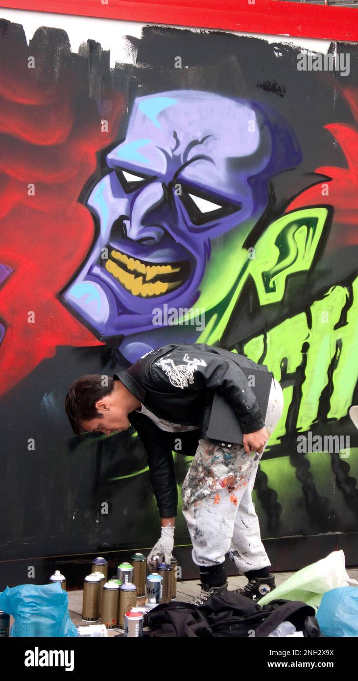 Graffiti show in Bacon St London E2. Artist working on building site ...