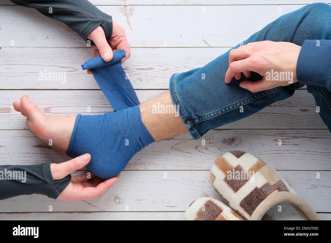 Feet trauma, injury. Adult wrapping compression bandage around sprained