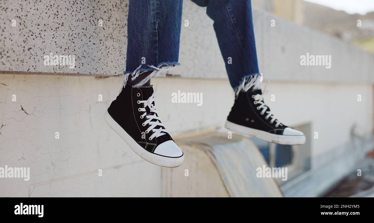 Rooftop, shoes and man in an urban city sitting on the top of a building for a view of the cityscape. Hipster, freedom and closeup of male feet with Stock Photo