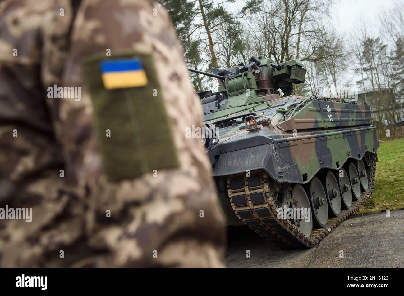 A Ukrainian soldier is standing in front of a Marder infantry fighting ...