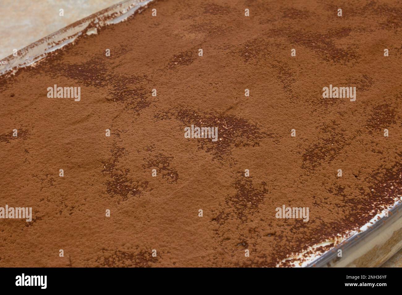 Close-up shot of the creamy texture of the first cocoa layer in a delicious and healthy homemade Tiramisu dessert. Delicious idea. Stock Photo
