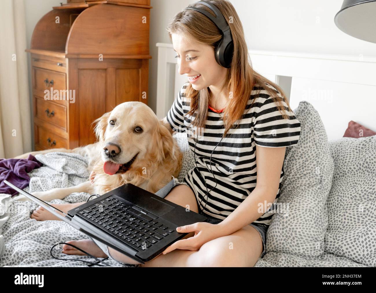 Girl with golden retriever dog in bed Stock Photo - Alamy