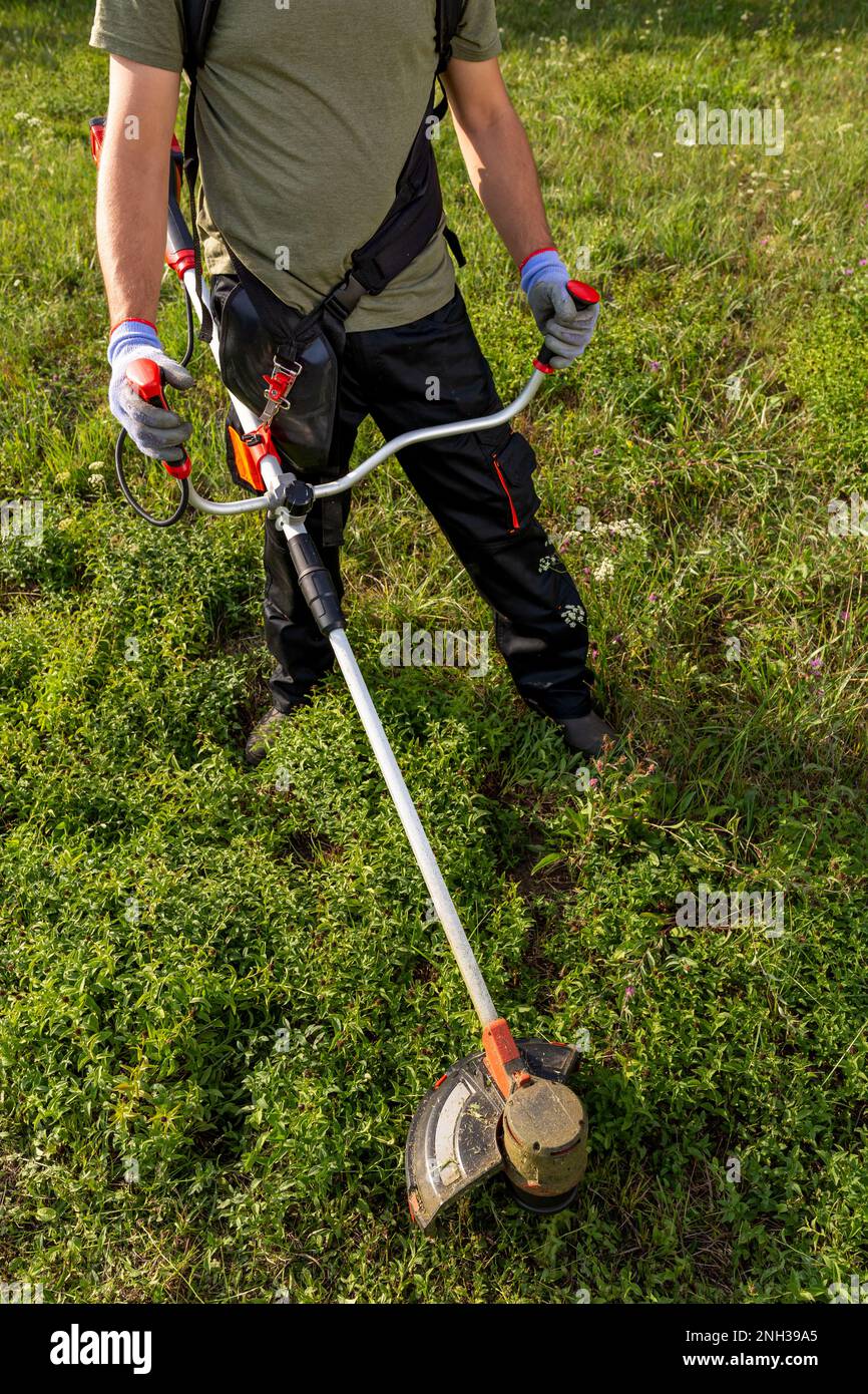 Worker using string lawn trimmer hi-res stock photography and images ...
