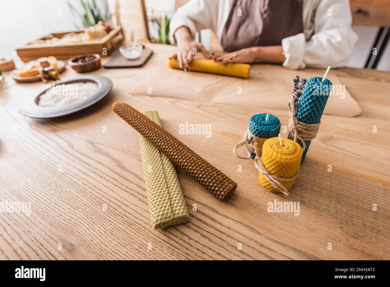 selective focus of natural wax sheets and handmade candles near cropped african american craftswoman on blurred background,stock image Stock Photo