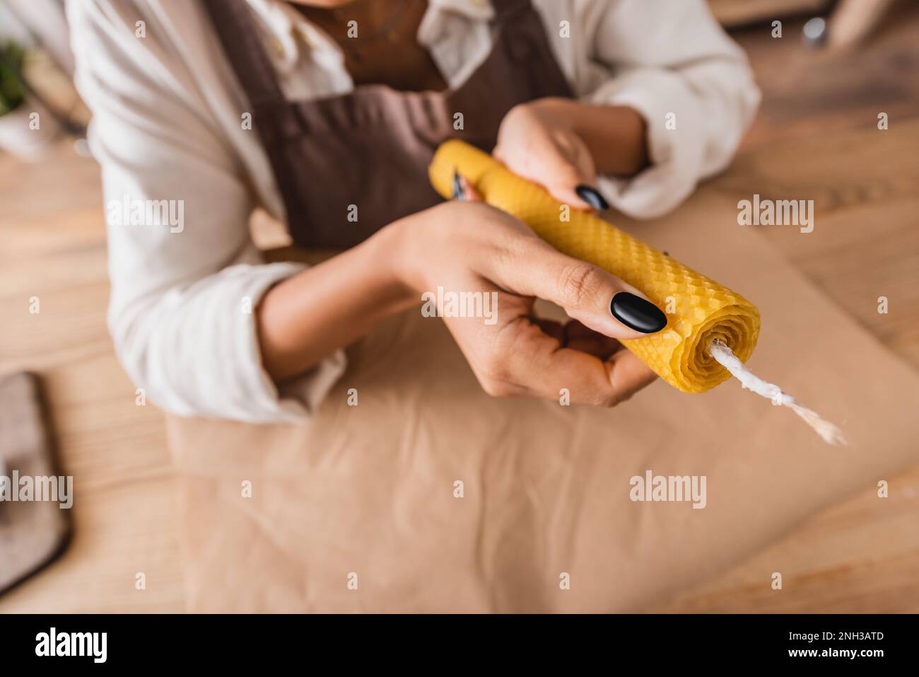 high angle view of cropped african american craftswoman holding homemade candle on blurred background,stock image Stock Photo