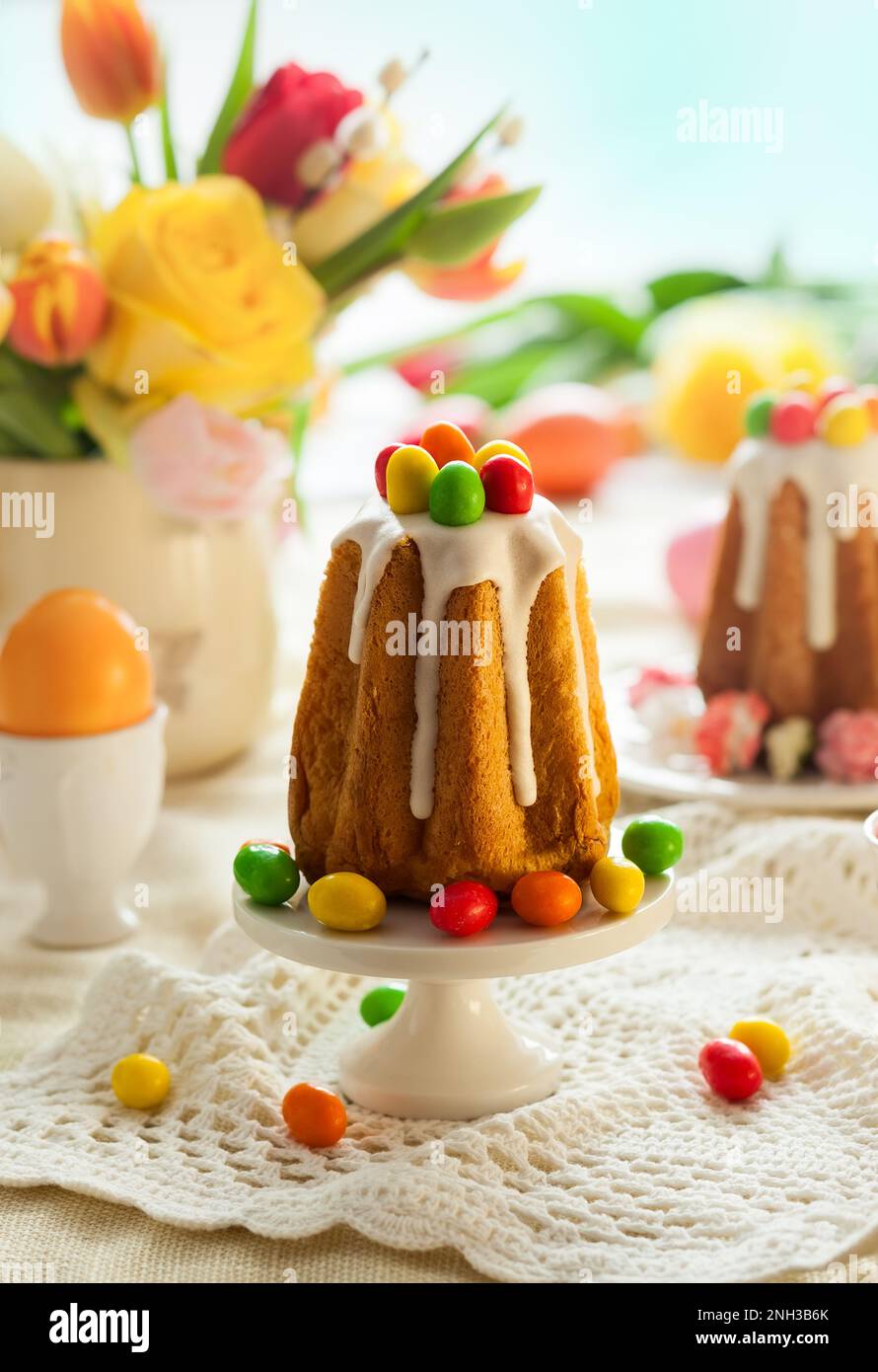 Easter table setting with spring flowers, cakes and easter eggs. Stock Photo