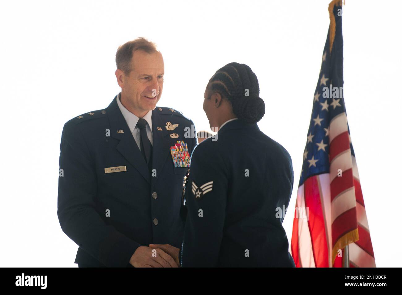 U.S. Air Force Maj. Gen. Corey Martin, left, 18th Air Force commander, presents Senior Airman Deniece Lobban, loadmaster with MOOSE 98, with the Distinguished Flying Cross during a ceremony at Travis Air Force Base, California, Dec. 9, 2022. Martin recognized 24 Airmen for their heroic actions during Operation Allies Refuge. The Distinguished Flying Cross is awarded to any officer or enlisted person of the U.S. armed forces for heroism or extraordinary achievement while participating in aerial flight. Stock Photo