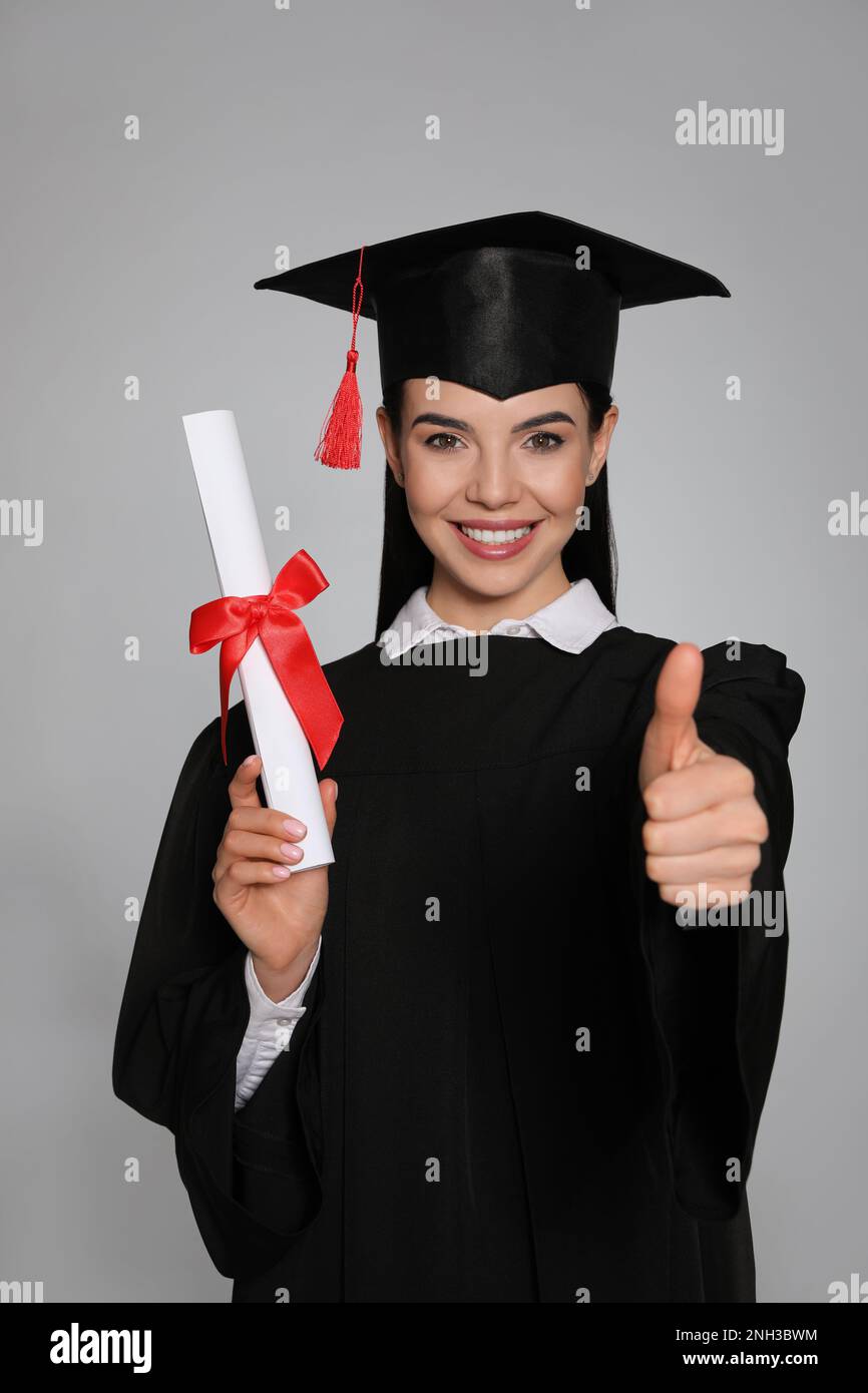 Happy student with graduation hat and diploma on grey background Stock ...