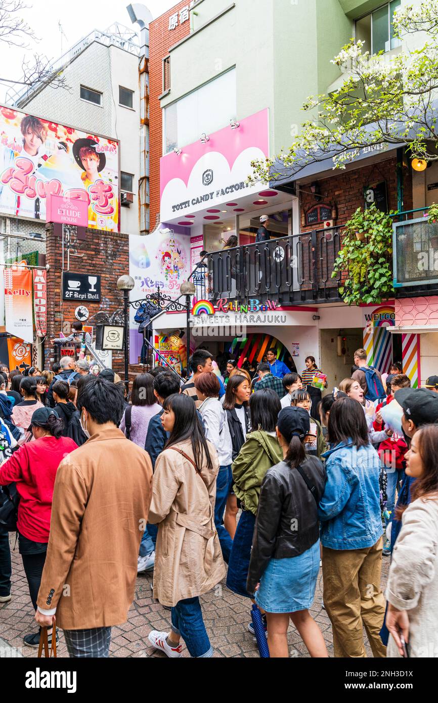 Harajuku, Tokyo. Crowds walking pass the Rainbow Sweets Harajuku store and the Totti Candy Factory, famous for its giant cotton candy. Daytime. Stock Photo