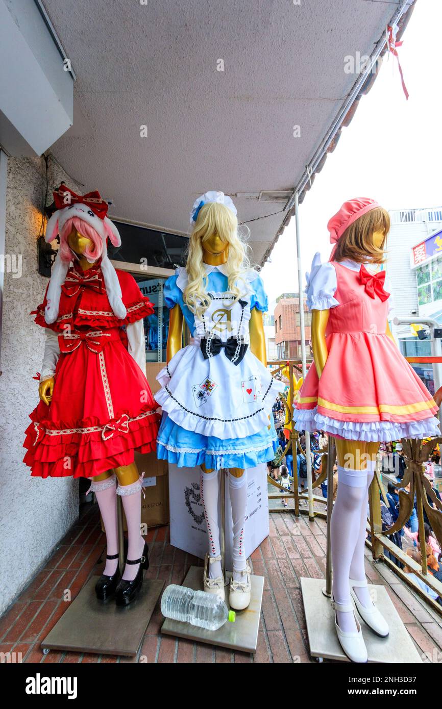 Three colourful Japanese Lolita style maid costumes including an alice in wonderland, on mannikins at a store in Takeshita Street, Harajuku, Tokyo. Stock Photo