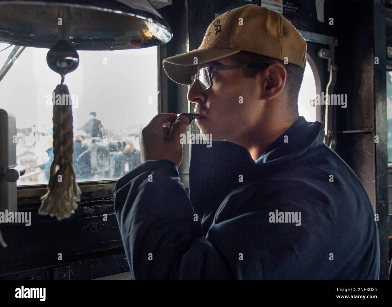 TOKYO BAY (Dec. 9, 2022) Boatswain’s Mate 3rd Class Aaron Regalado, from Seymour, Conn., blows