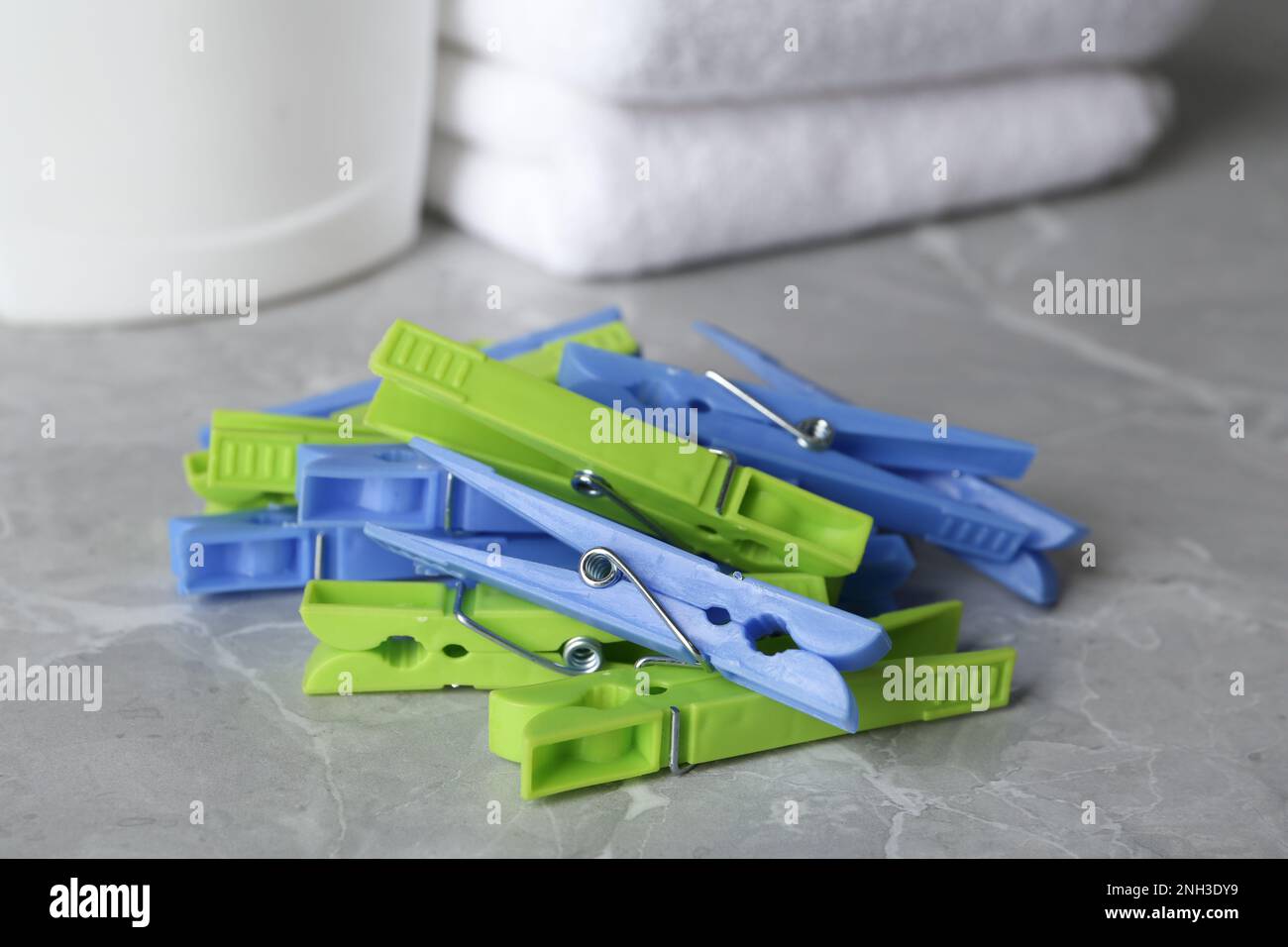 Colorful plastic clothespins on grey table, closeup Stock Photo