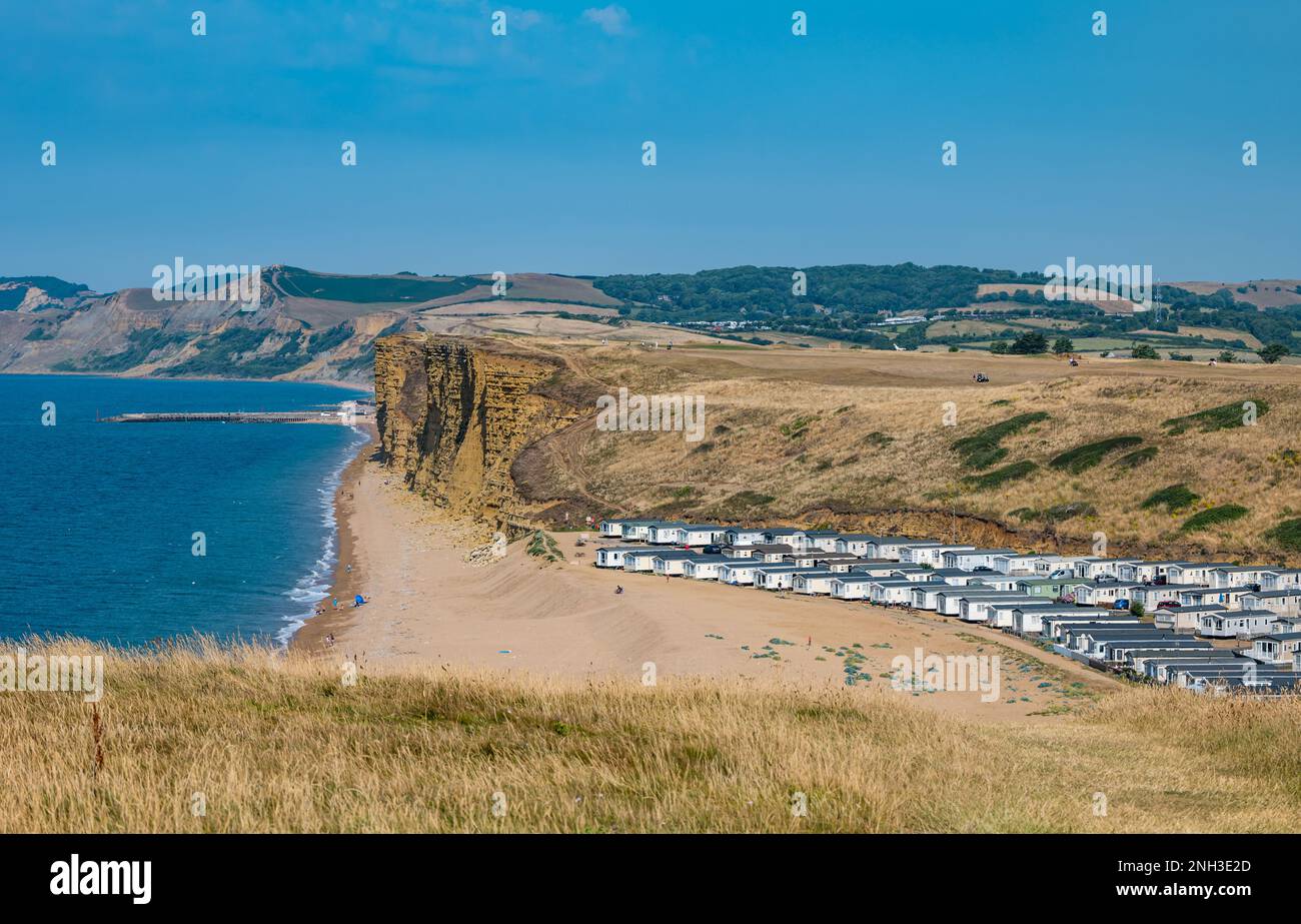 Mobile homes holiday on beach next to limestone cliffs