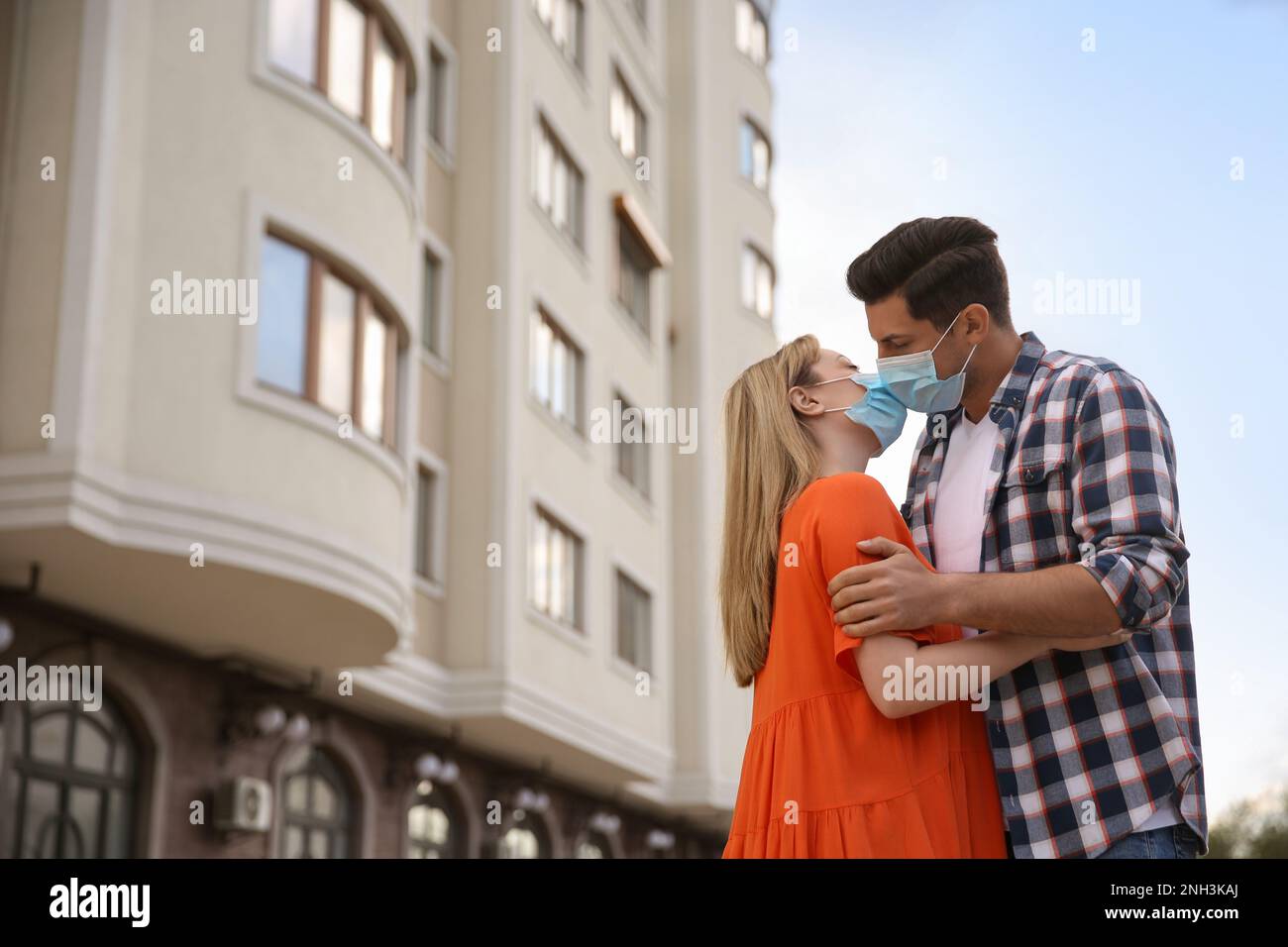 Couple in medical masks trying to kiss outdoors Stock Photo - Alamy
