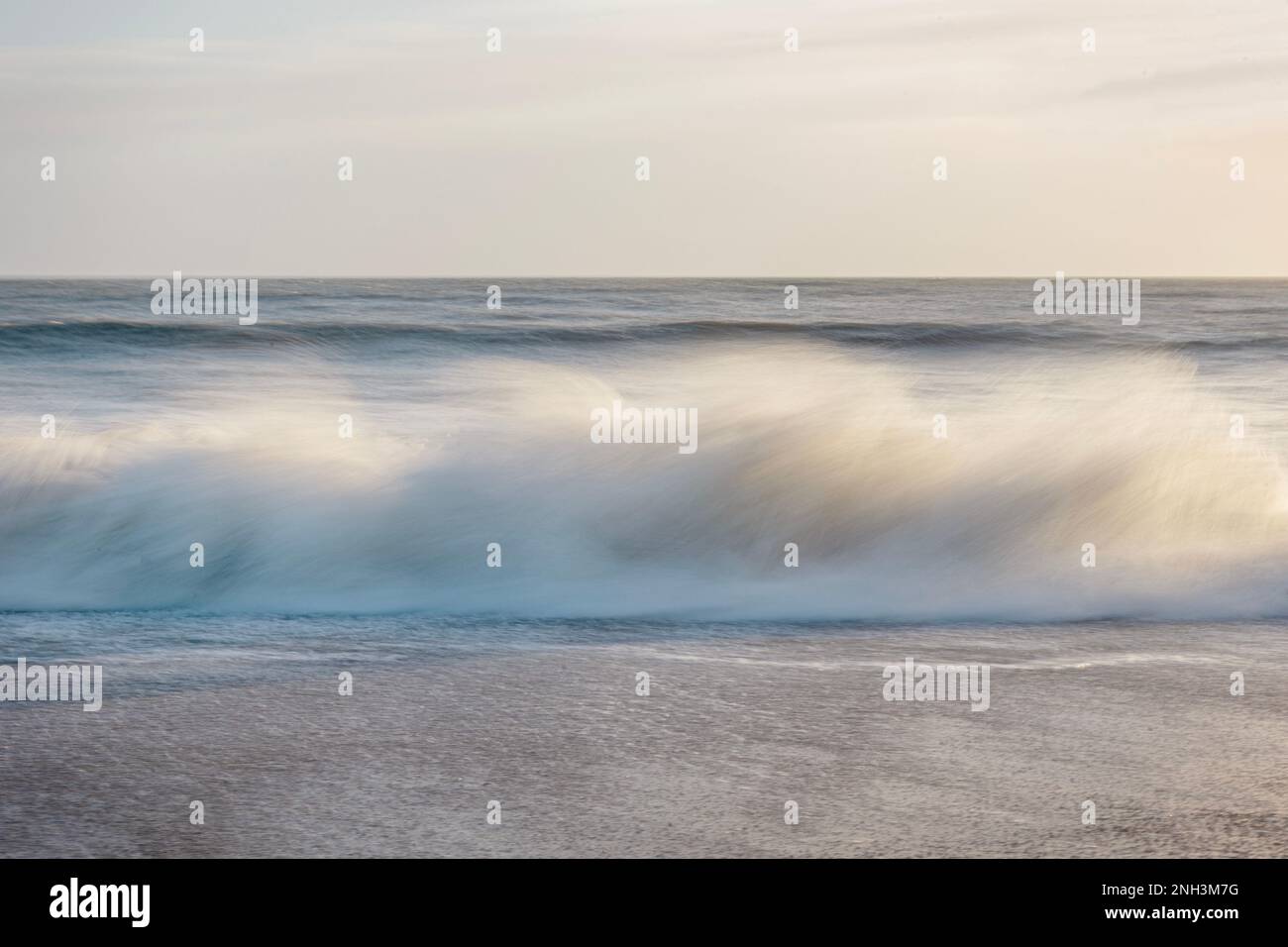 Intentional camera movement of a wave crashing on the beach at Worthing, West Sussex, UK Stock Photo