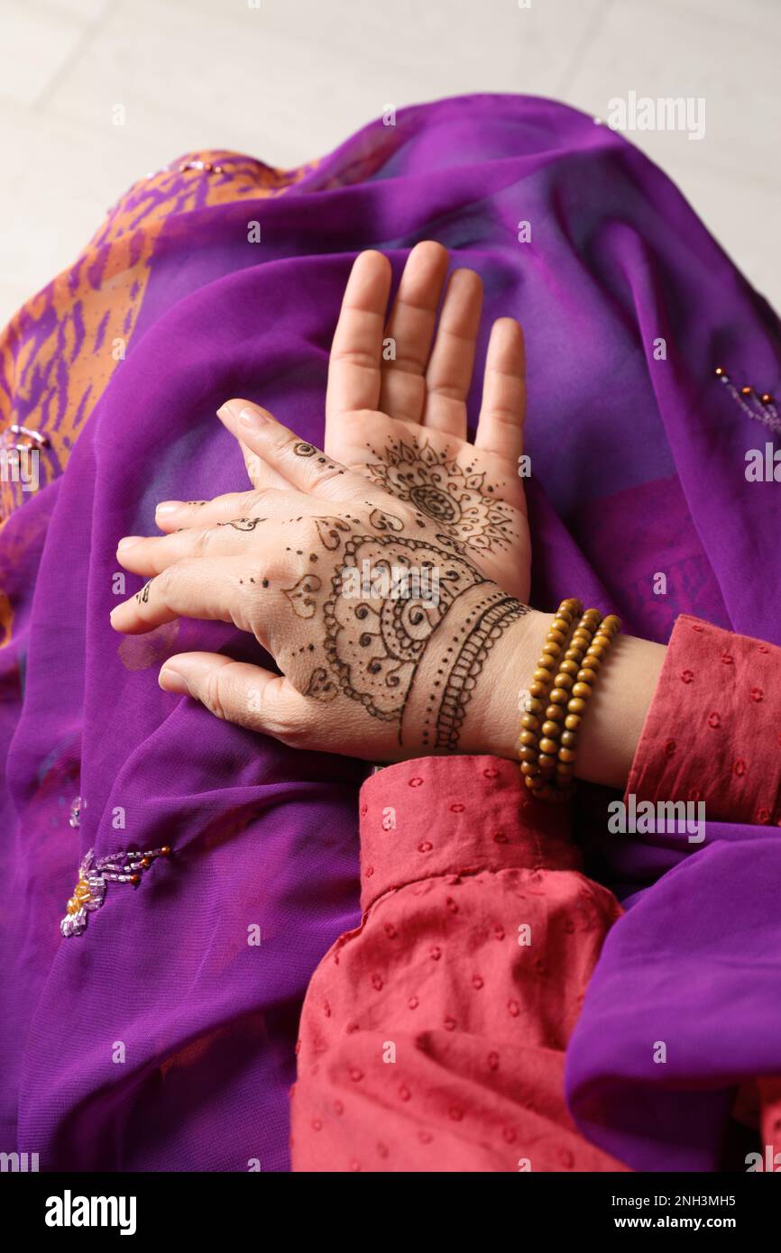 Woman with beautiful henna tattoos on hands, closeup. Traditional