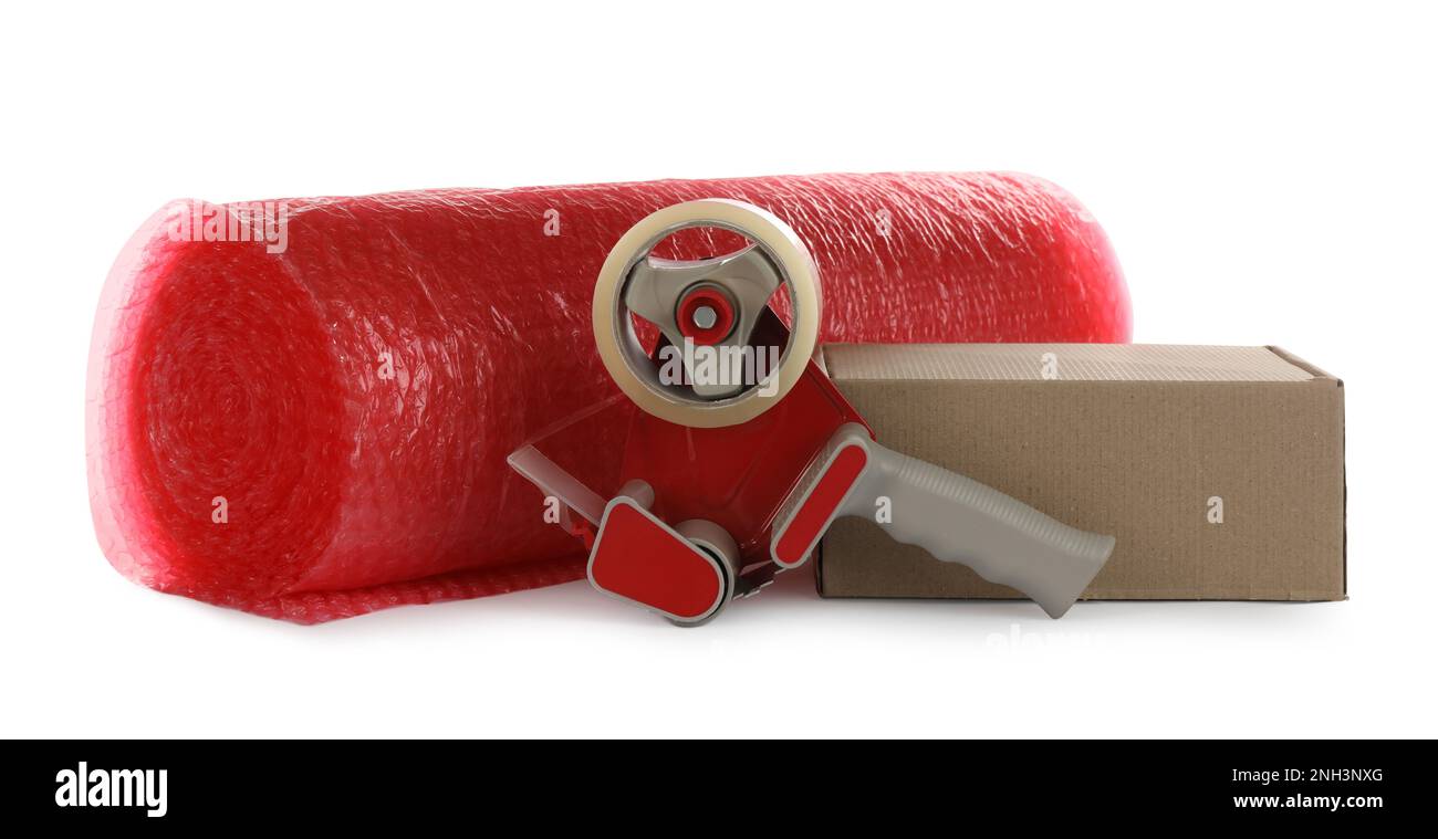 Bubble wrap roll, cardboard box and tape dispenser on white background