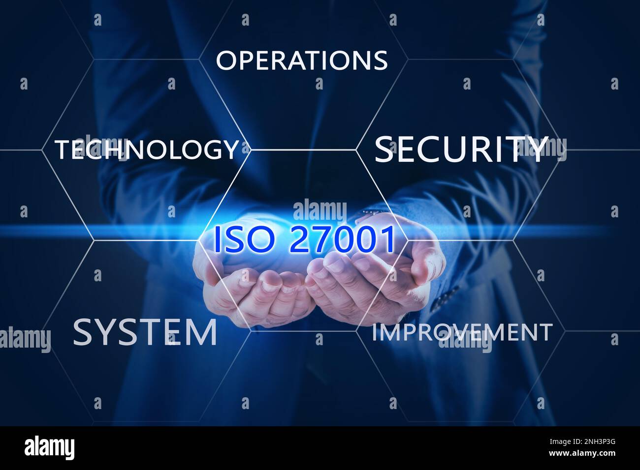 Businessman demonstrating text ISO 27001 on dark background, closeup Stock Photo