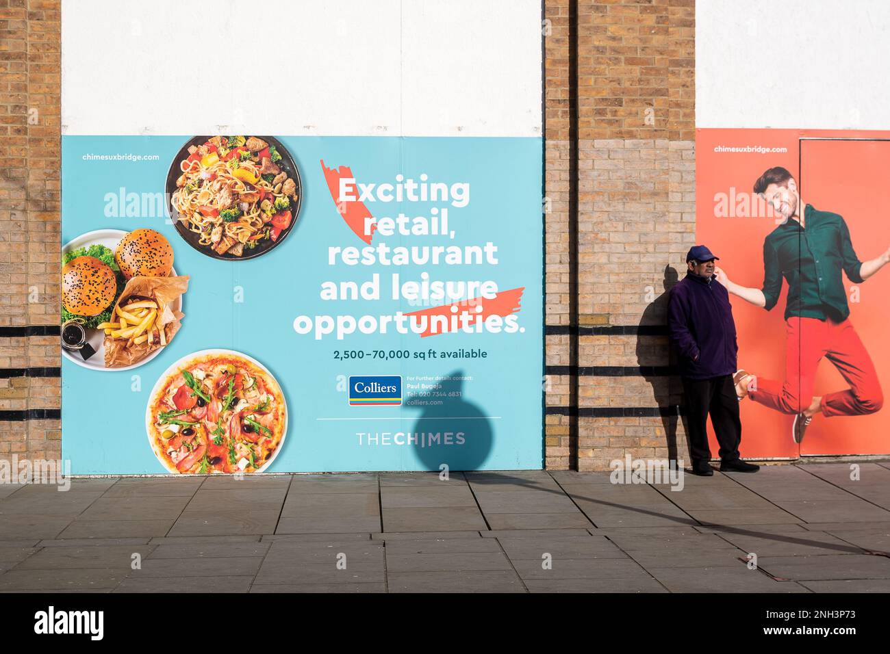 Uxbridge, London Borough of Hillingdon, UK. 9th February, 2023. A man stands next to an advert for retail and restaurant opportunties in the Chimes Shopping Centre. Credit: Maureen McLean/Alamy Stock Photo