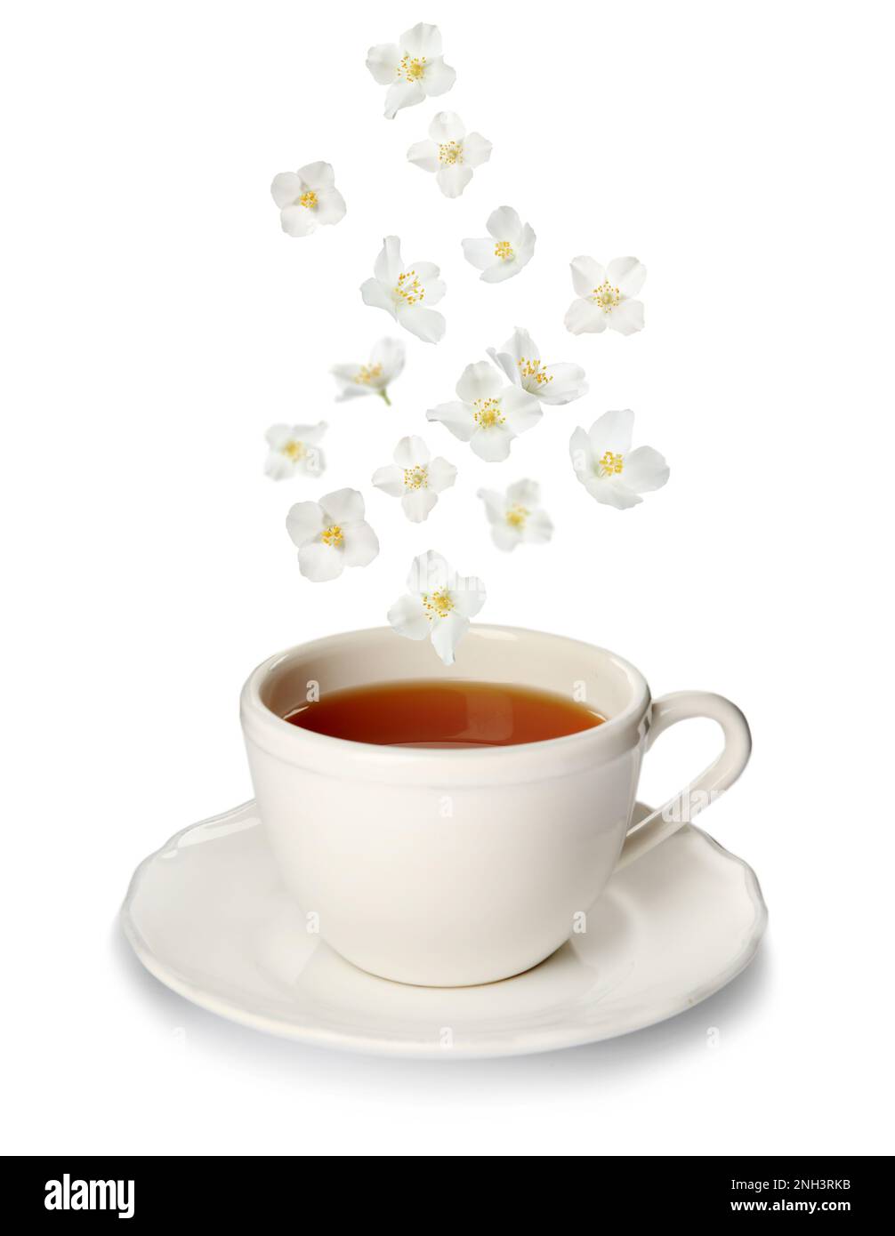 Beautiful jasmine flowers falling into cup of hot freshly brewed tea on