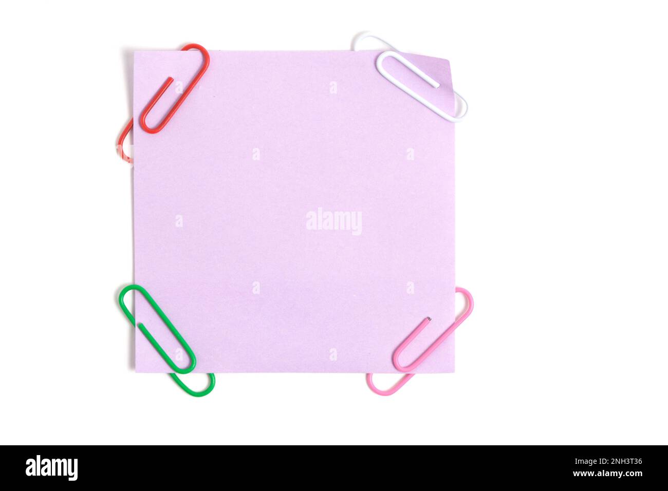 Lilac paper sticker for written notes and paper clips on a white background Stock Photo