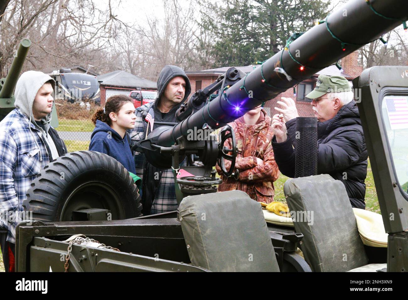 Illinois State Military Museum volunteer John Kennedy of Springfield, Ill., explains to Bill Farnum of Farmer City, Ill., and his family how a 106mm Recoilless Rifle used a 50-caliber single-shot rifle with illumination rounds to aim. The 106 was mounted on a M38A1 Jeep and was used by the U.S. Army during the Korean War. Kennedy volunteered to assist the Illinois State Military Museum during its Dec. 10 Christmas at the Front event at the museum in Springfield. The Illinois State Military Museum's mission is to preserve and exhibit the military heritage of the Illinois National Guard. Stock Photo