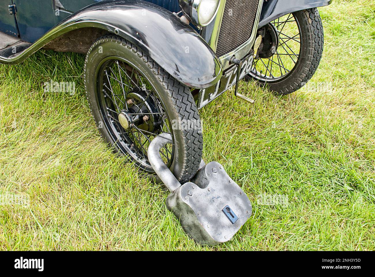 Massive lock on the spoked wheel of a vintage car. A new take on car security. No it is not photoshopped, Stock Photo