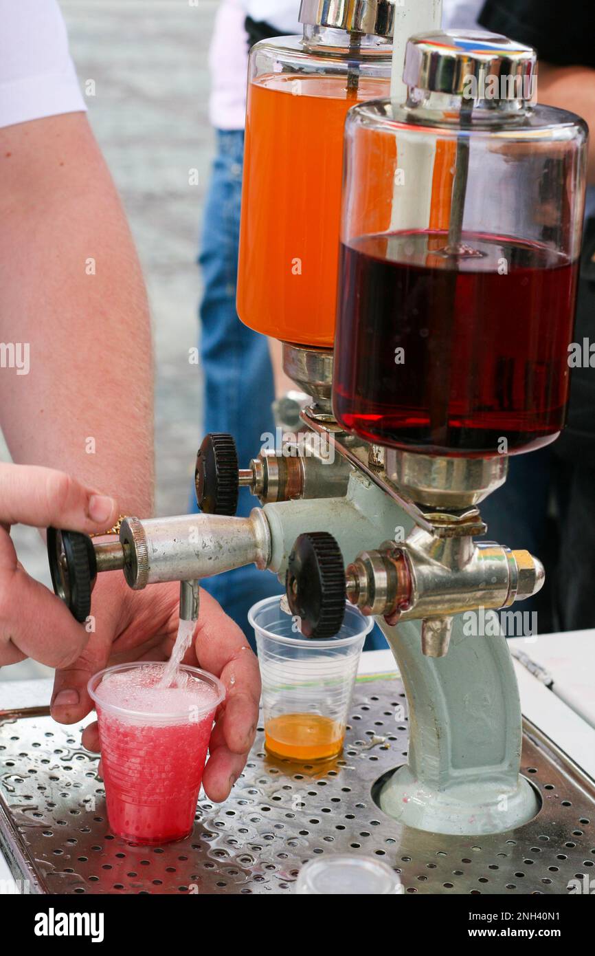 Pouring carbonated drink from saturator. Tap and syrup glass tanks of flavoured soda maker drink stand Stock Photo