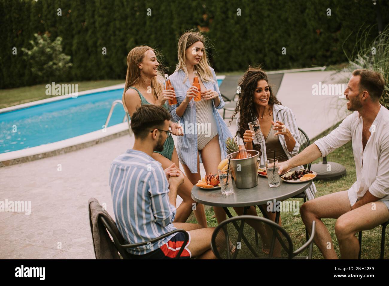A group of young adults enjoying a leisurely summer party with food
